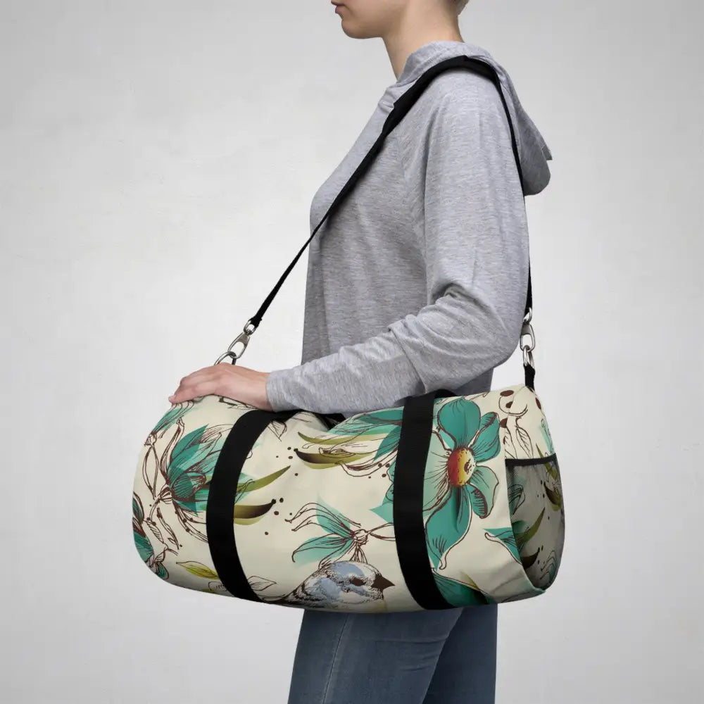 Cylindrical floral duffel bag with black straps, mesh pocket, perfect travel companion