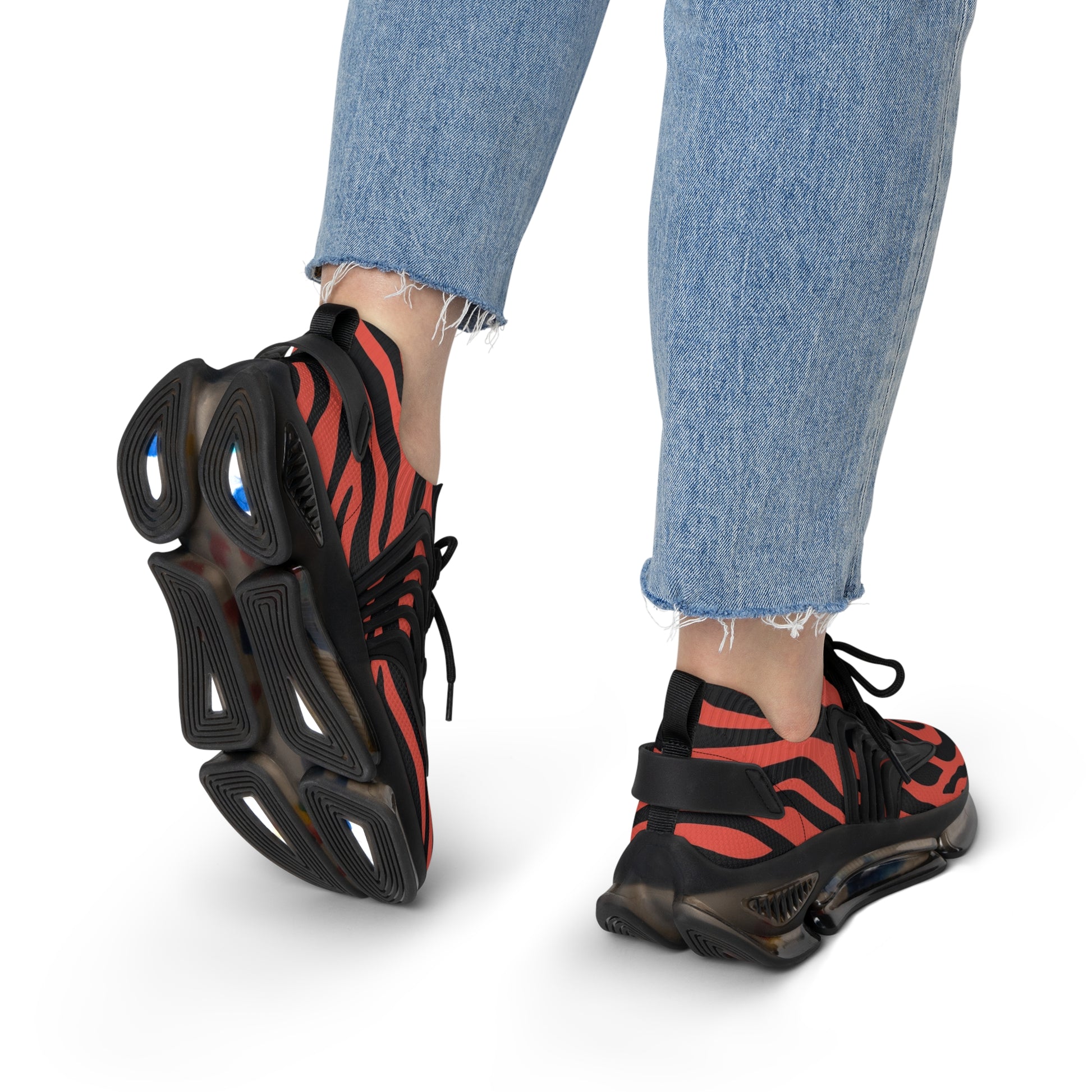 Women's red-and-black zebra mesh sneakers on feet with black laces and chunky sole