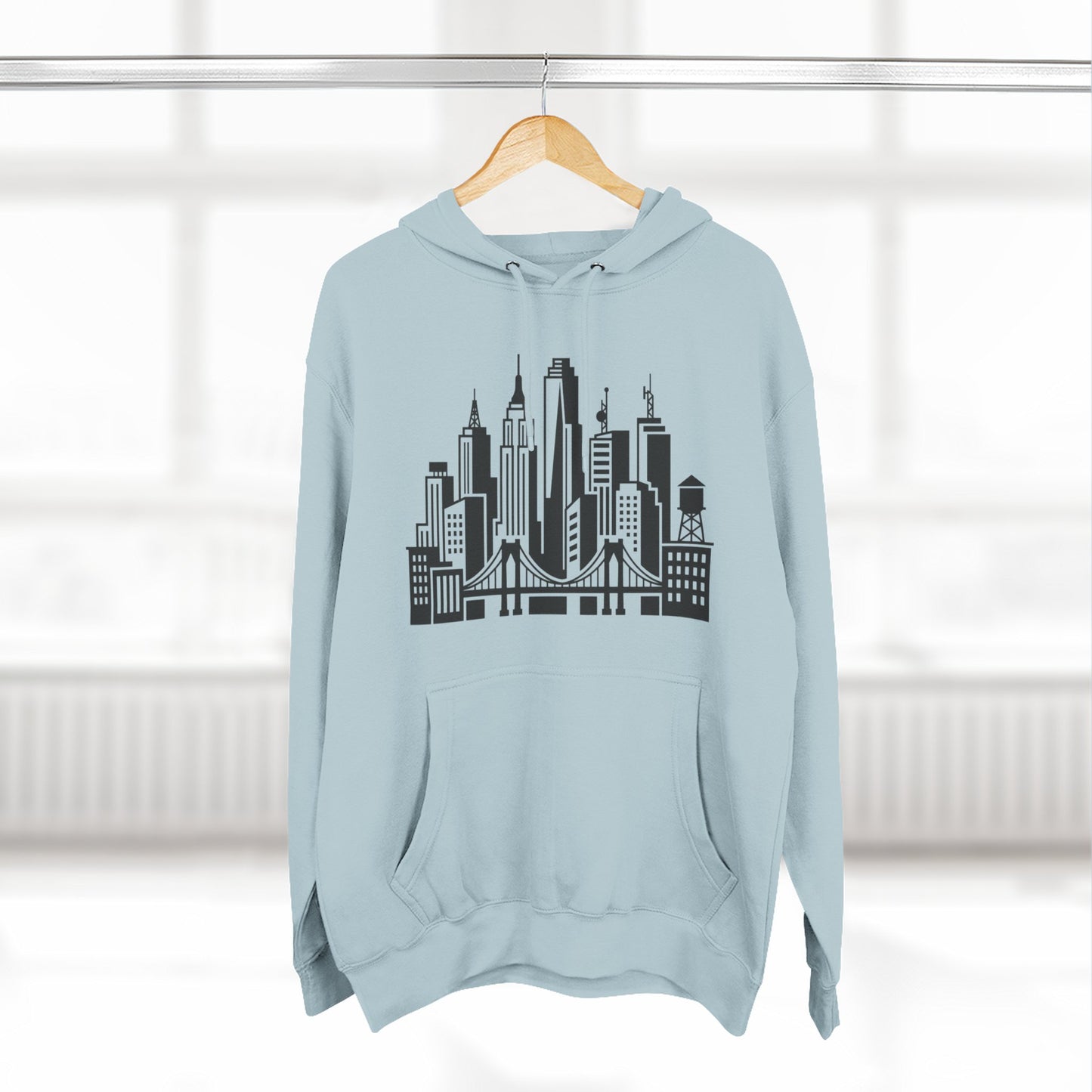 Light blue unisex hoodie on hanger with large city skyline and bridge graphic