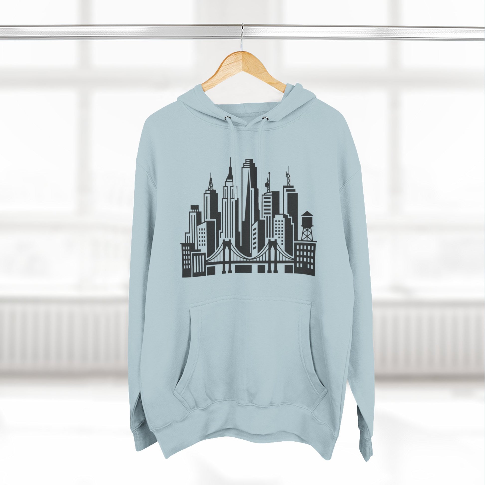 Light blue unisex hoodie on hanger with large city skyline and bridge graphic