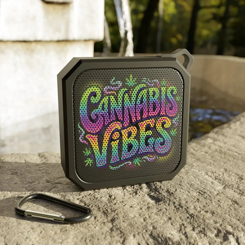 Black portable bluetooth speaker with rainbow cannabis vibes graphic and leaf motifs on perforated grille for outdoor use