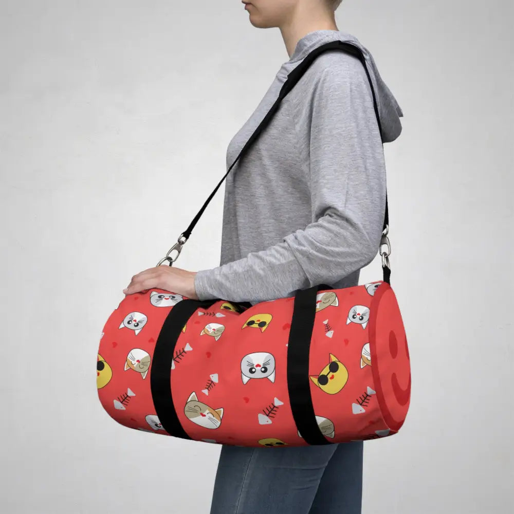 Red duffel bag with cartoon cat faces and fish bones, perfect pet travel tote
