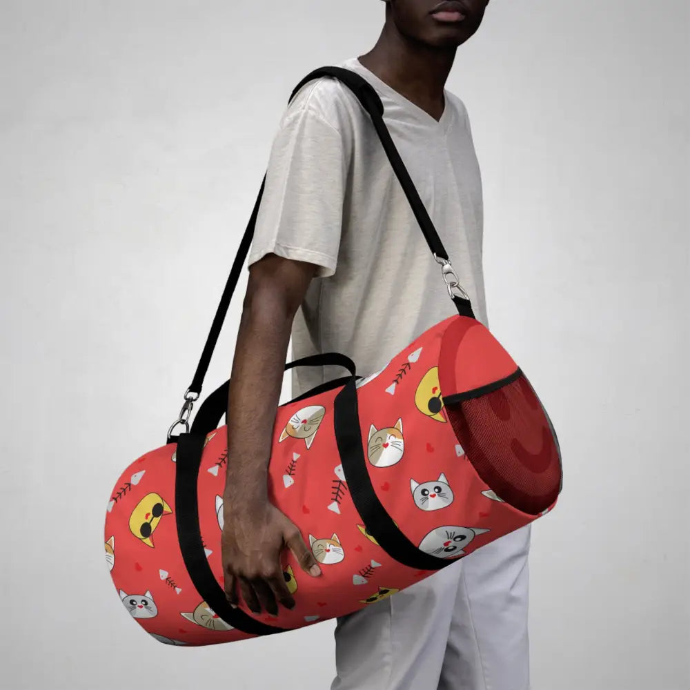Red duffel bag with cat faces and fishbone patterns, perfect pet travel companion