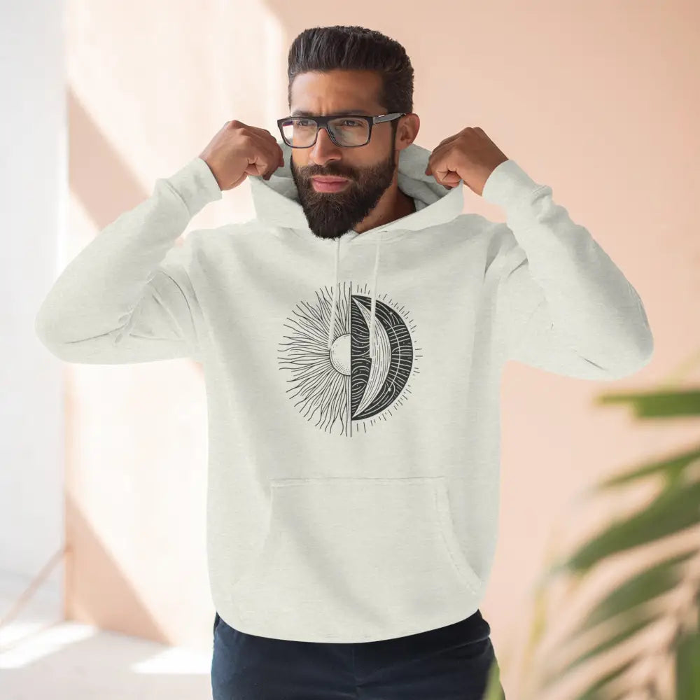 Cream-colored Celestial Harmony unisex hoodie with sun and moon graphic, cozy fleece, spacious kangaroo pocket, and twill tape neck