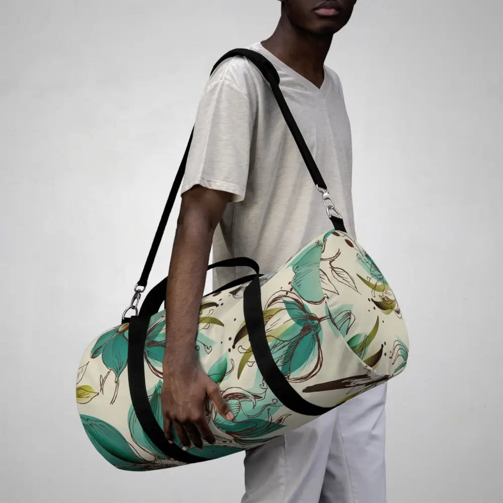 Teal floral pattern cylindrical duffel bag with black straps, perfect travel companion with multiple compartments