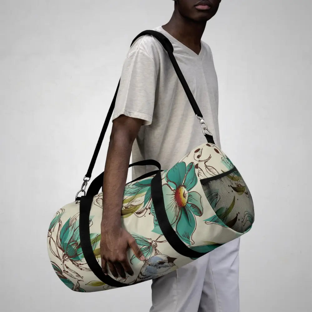 Teal floral and bird pattern on a robust duffel bag, perfect travel companion with multiple compartments