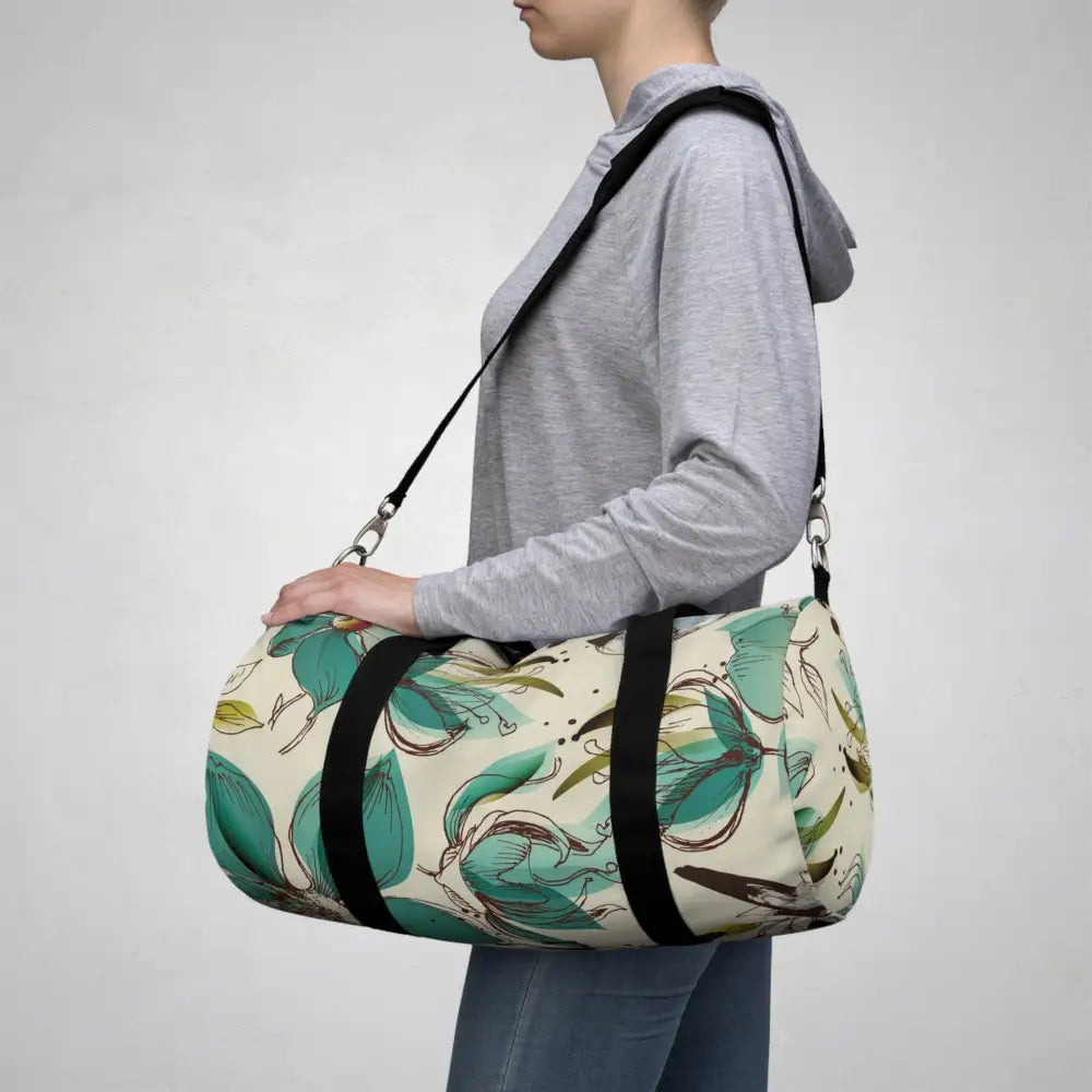 Cream-colored floral duffel bag with black straps, perfect travel companion with multiple compartments