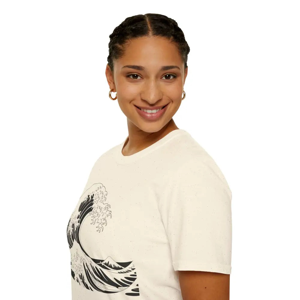Woman with braided hair wearing a cream Ocean Wave Unisex T-Shirt with black wave design