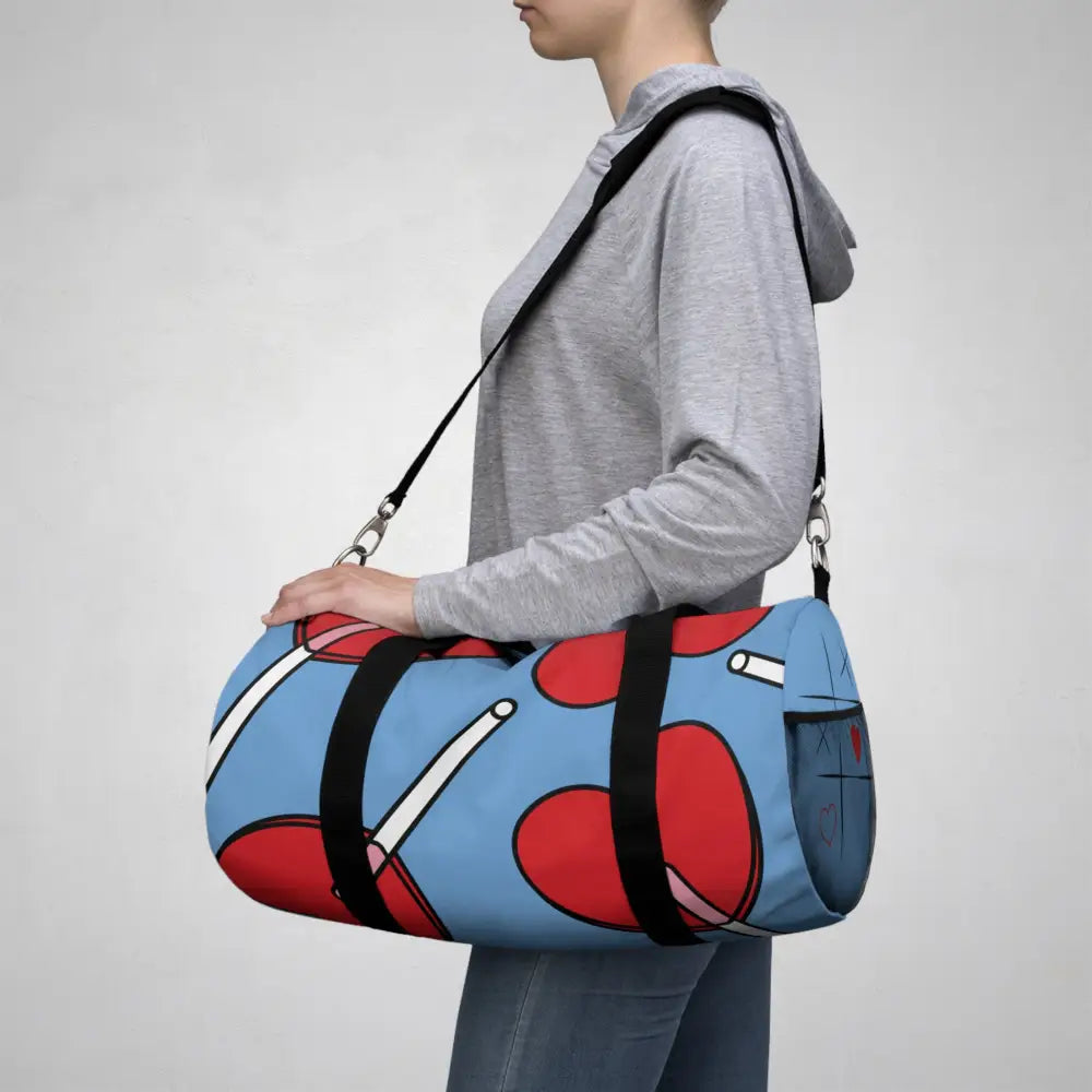 Light blue stylish duffel bag with red heart and white stick designs for travel or gym