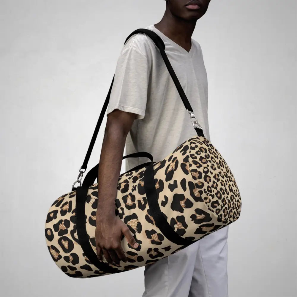 Chic leopard print duffel bag with black straps, adjustable shoulder strap, and internal zipper pocket