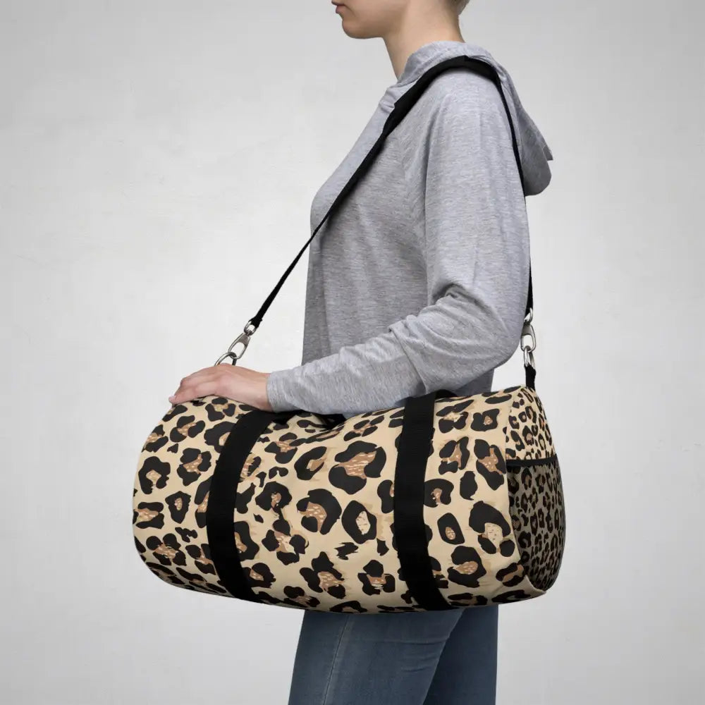 Chic leopard print duffel bag with black straps, adjustable shoulder strap, and internal zipper pocket