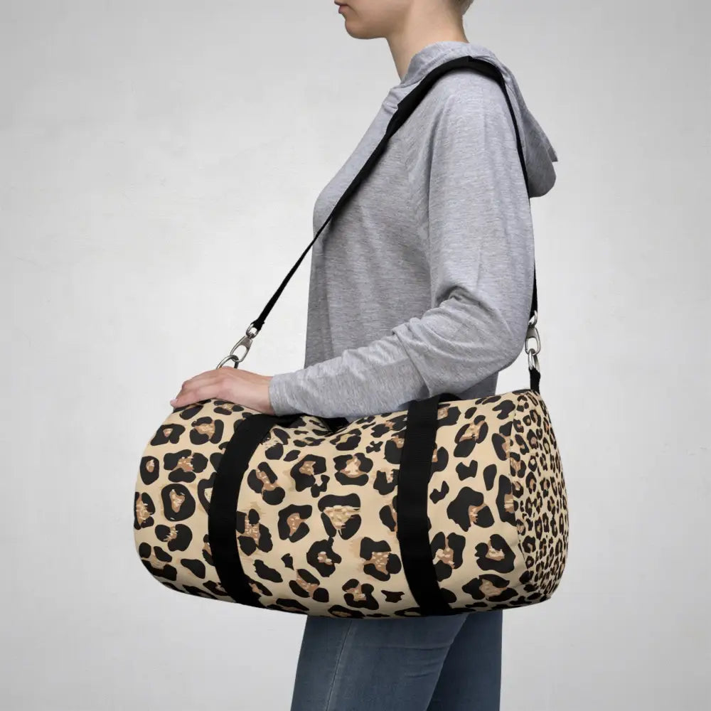 Chic leopard print duffel bag with black straps, adjustable shoulder strap, and internal zipper pocket