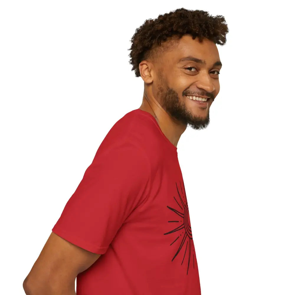 Man in a red unisex softstyle T-shirt with sun graphic, ideal for summer and outdoor adventures