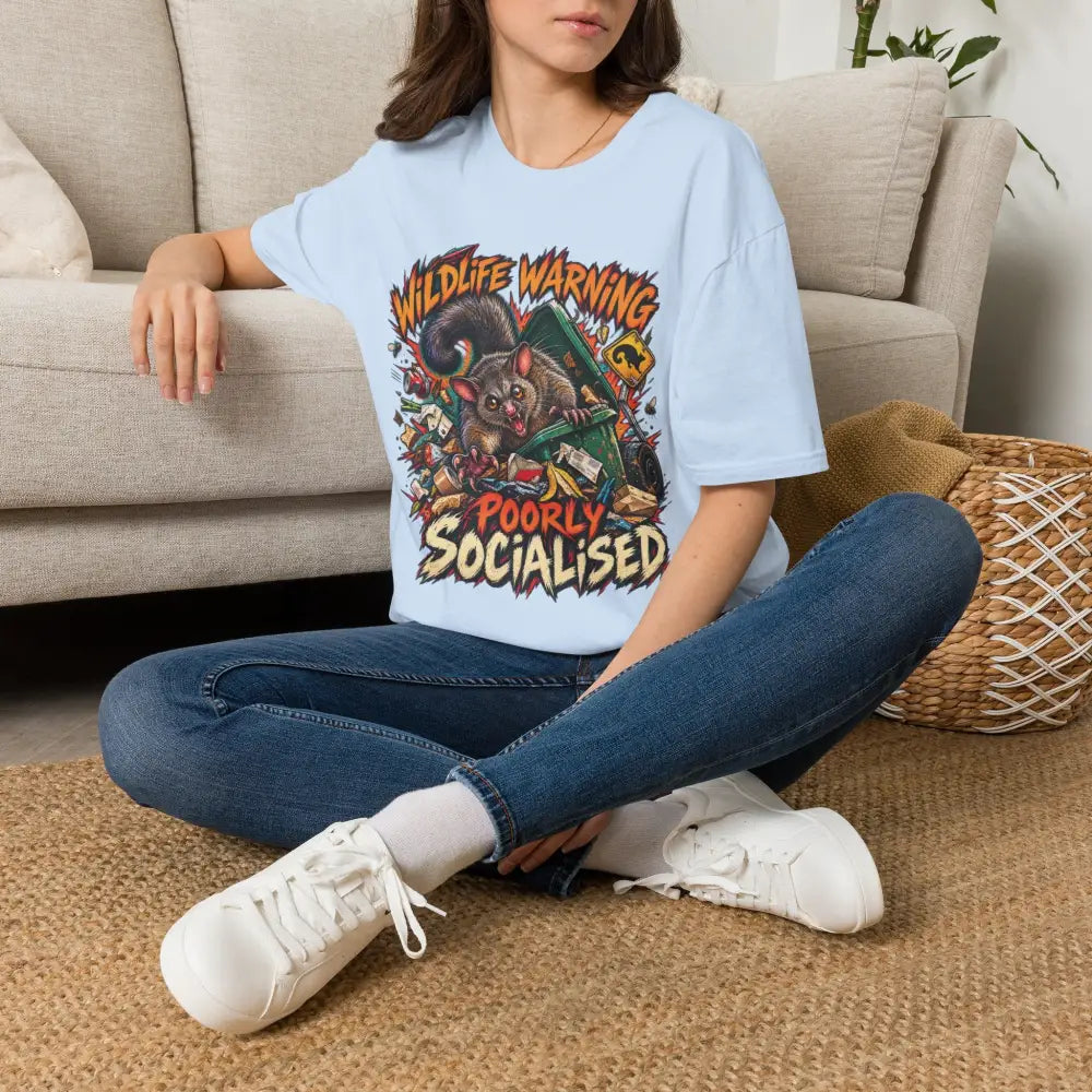 Light blue ring-spun cotton unisex t-shirt with colorful cartoon possum graphic and wildlife warning text low heat care instructions