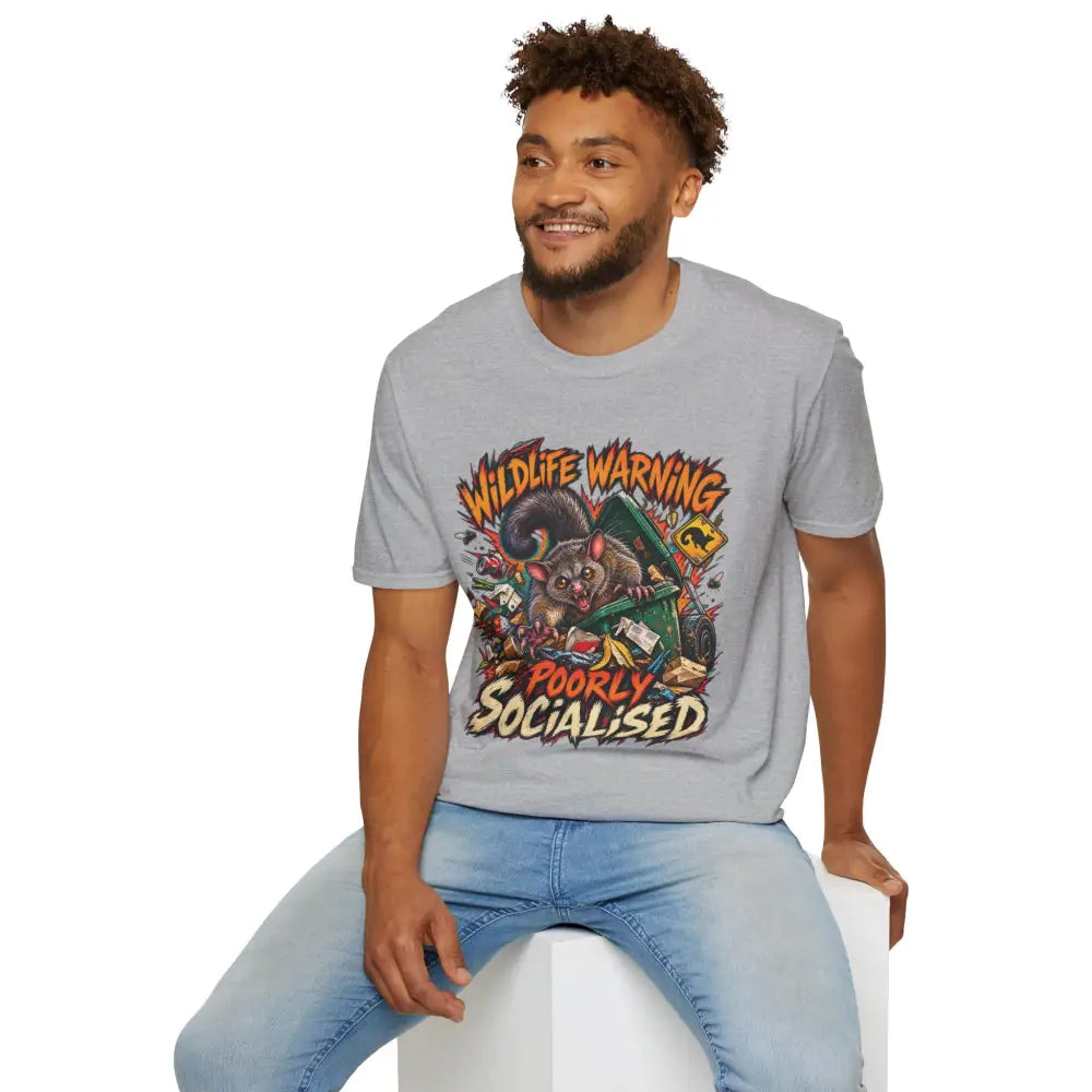 Gray unisex ring-spun cotton t-shirt featuring a cartoon possum graphic with wildlife warning and poorly socialised text care instructions recommend low heat