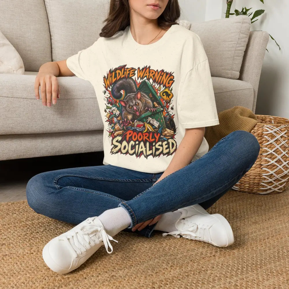 Cream-colored unisex ring-spun cotton t-shirt with a cartoon possum graphic and wildlife warning text care instructions low heat