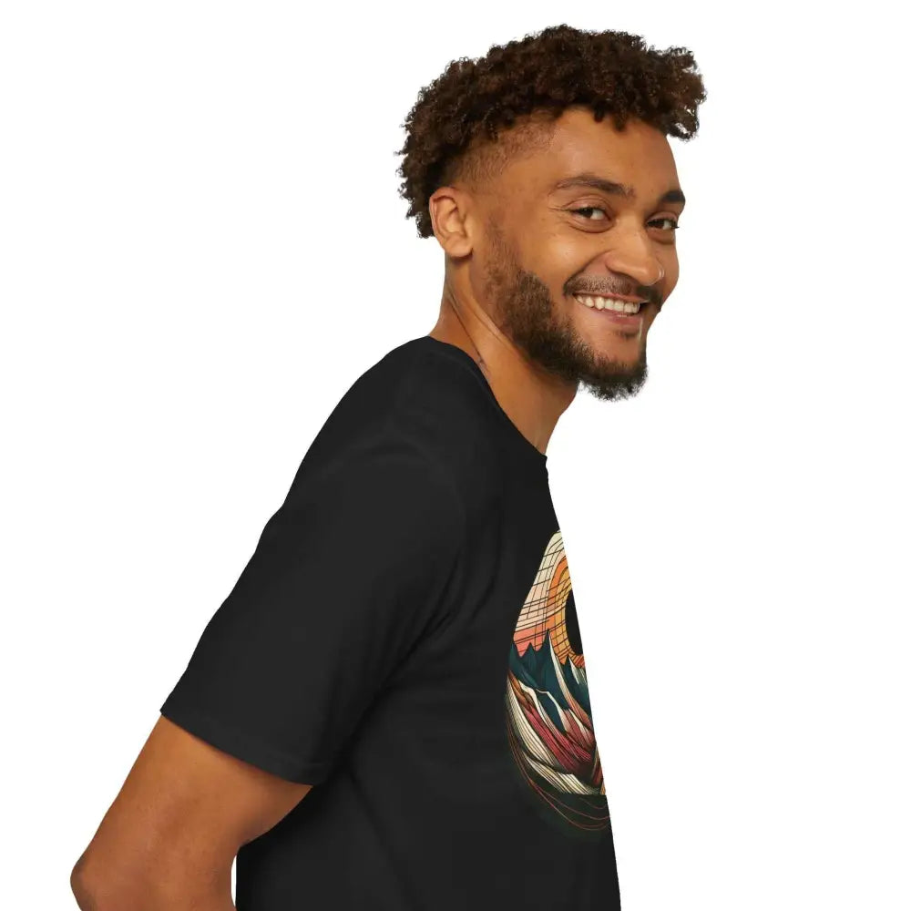 Man with beard and curly hair wearing a vintage mountain vibes softstyle t-shirt with elastic ribbed collar